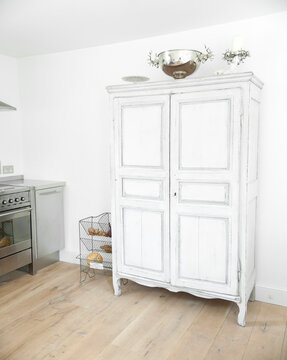 White painted cupboard unit in kitchen of cottage interior, UK.