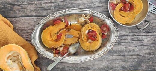 Roasted slices of pumpkin and cherry tomatoes on a silver tray