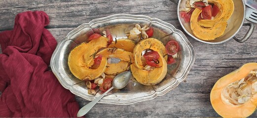 Roasted slices of pumpkin and cherry tomatoes on a silver tray