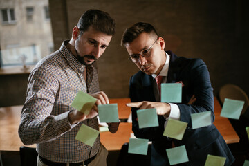 Businessmen in the office. Colleagues in conference room making a business plan. Two man working together on new project.