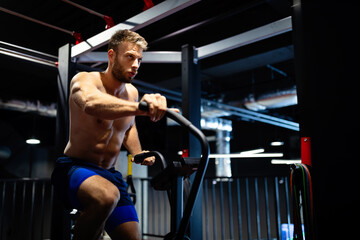 Fototapeta na wymiar Portrait of a handsome man workout on a fitness machine at gym