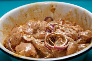 Chicken fillet in soy sauce with lemon juice marinated in a dish.