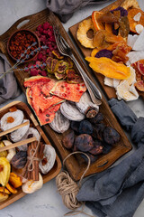dried fruits. Many different dried fruits on wooden plates on a concrete background.