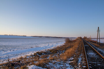 Fototapeta na wymiar Landscape near the railway tracks during a beautiful winter sunset