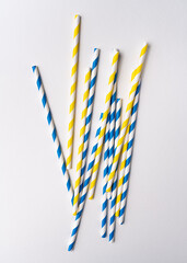 Drinking Striped blue and yellow paper straws on white background © N L