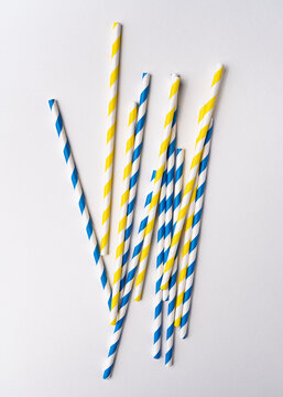 Drinking Striped blue and yellow paper straws on white background