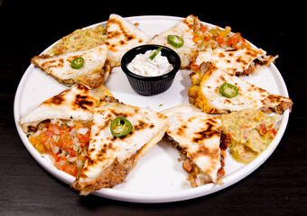 Comida mexicana, com deliciosa culinária mexicana, construção 45º sobre fundo preto. Nachos, burritos, guacamole, tacos, pimenta etc.