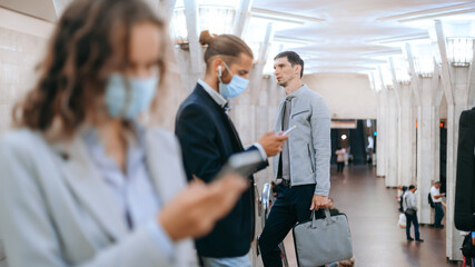 Naklejka premium people in protective masks standing at the subway station .