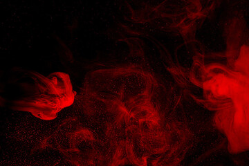 Abstract red smoke moves on black background. Beautiful swirling smoke.