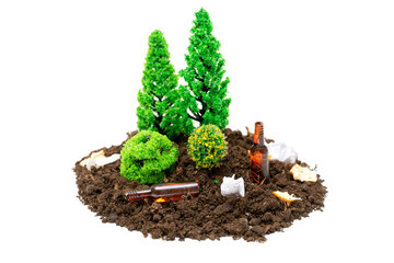Miniature toy forest setup with a lot of rubbish, tiny glass bottles and paper lying around.The concept of keeping forests and parks clean.