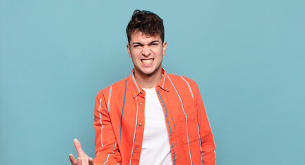 young man looking angry, annoyed and frustrated screaming wtf or what’s wrong with you