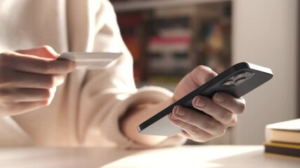 Female hand holding credit card and shopping online. Easy pay using digital gadget. Girl using laptop at home. Happy woman with compact computer and bank card shopping online. Lifestyle 4K - Powered by Adobe