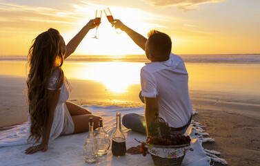 A gentle romantic date on the ocean during the magical sunset. A girl and a guy in white clothes...