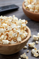 Vertical image of a large wooden bowl with popcorn