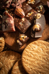 Pieces of pink and dark chocolate on rustic wooden background