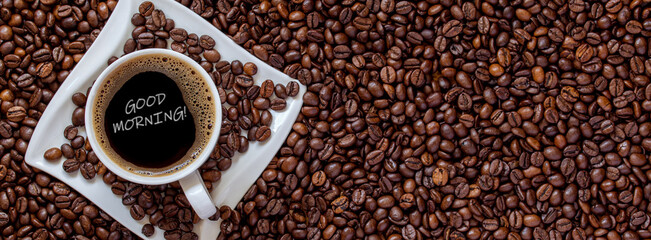 good morning - cup of coffee on roasted coffee beans background	
