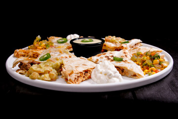 Comida mexicana, com deliciosa culinária mexicana, construção 45º sobre fundo preto. Nachos, burritos, guacamole, tacos, pimenta etc.