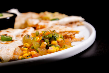 Comida mexicana, com deliciosa culinária mexicana, construção 45º sobre fundo preto. Nachos, burritos, guacamole, tacos, pimenta etc.