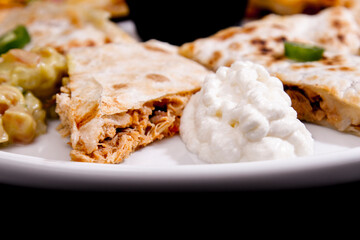 Comida mexicana, com deliciosa culinária mexicana, construção 45º sobre fundo preto. Nachos, burritos, guacamole, tacos, pimenta etc.