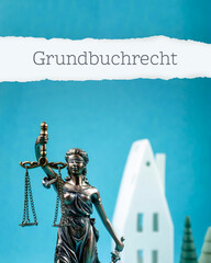 Grundbuchrecht. Justitia mit Haus und Bäumen. Blauer Hintergrund. Symbol für Anwalt, Immobilien- oder Mietrecht.