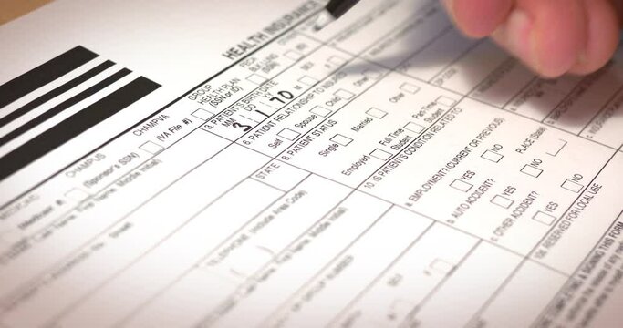 A slow dolly macro close-up shot filling out a generic health insurance claim form. Data written are fictional.  	