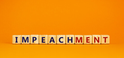Impeachment symbol. Wooden cubes with the word 'impeachment'. Beautiful orange background, copy space. Business, impeachment concept.