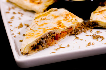 Comida mexicana, com deliciosa culinária mexicana, construção 45º sobre fundo preto. Nachos, burritos, guacamole, tacos, pimenta etc.