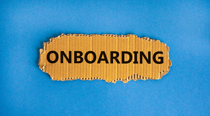 Onboarding symbol. The concept word 'onboarding' on the piece of cardboard. Beautiful blue background, copy space. Business and onboarding concept.