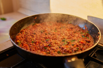 Spaghetti bolognese sauce being fried on a pan
