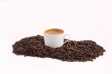 a cup of coffee on top of coffee beans