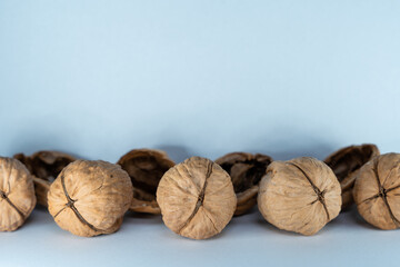 Walnuts stand on a white background composed of different variations and some of them are just empty shells