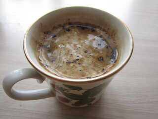 Black coffee with froth in a porcelain cup