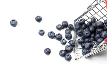 Fresh blueberries falling from metal shopping box isolated on a white background. 