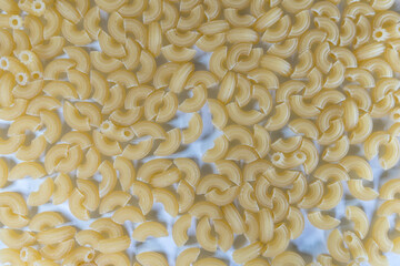 yellow pasta sprinkled on a white surface forms an evenly interesting background