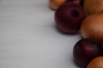 Onions yellow and red on white wooden background