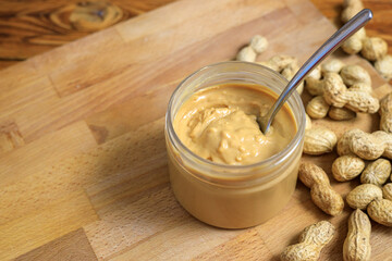Opened jar with peanut butter and spoon in it