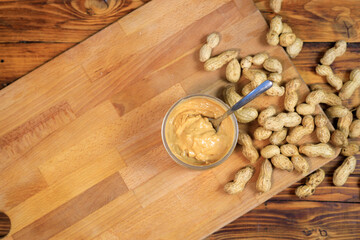 Opened jar with peanut butter and spoon in it