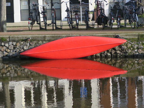 red coloured  cannoe hanging on the quay of a canal    