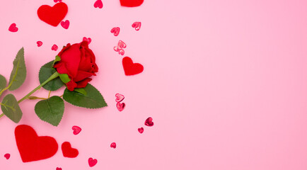 Rose and red hearts on pink background, top view. Copyspace, a Valentine's Day concept.