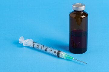 Disposable Injection And Amber Color Vial On Blue Background