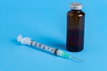Disposable Injection And Amber Color Vial On Blue Background