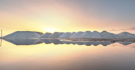 Sea salt production near Pomorie salt lake, Bulgaria. Piles of salt in factory at sunset with...