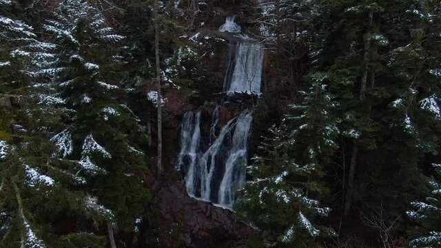 Aerial footage of Waterfall in Voges France with snowy conditions, medium shot, rising