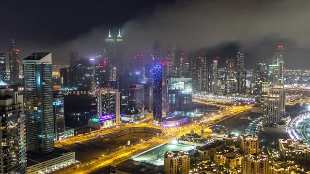 Aerial view of a big modern city at night timelapse with night traffic and illuminated skyscrapers, office buildings. Business bay, Dubai, United Arab Emirates.