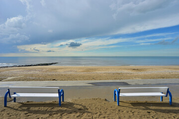 Fototapeta na wymiar Deux bancs face à la mer, à Blonville-sur-Mer (14910) plage, département du Calvados en région Normandie, France