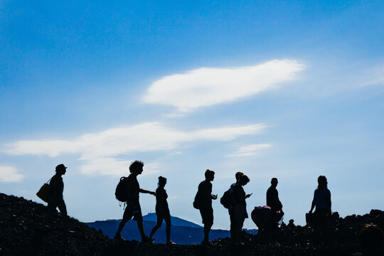 Silhouette People Hiking On Mountain Against Sky