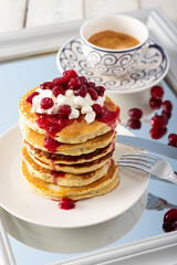 Pancake tower with cranberry marmalade, fresh cottage cheese and coffee for breakfast on  mirror