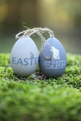 Easter holiday. Easter eggs  on a moss tree stump in a sunny spring forest.Easter beautiful natural background.Spring religious holiday