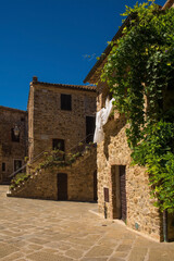 Fototapeta na wymiar Historic stone residential buildings in the village of Montemerano near Manciano in Grosseto province, Tuscany, Italy 
