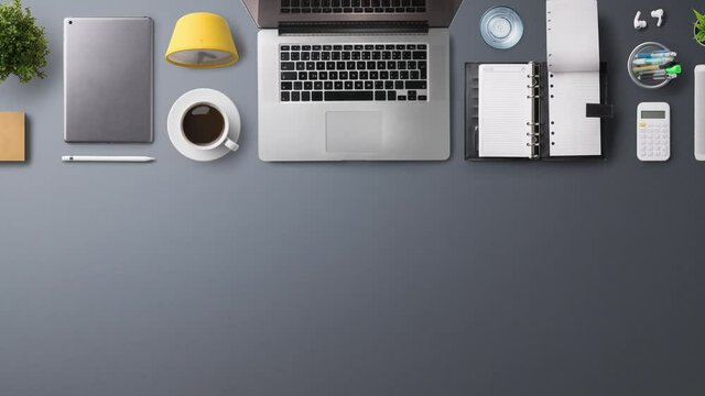 Flat lay top view office desk working space with laptop and office supplies on black background.